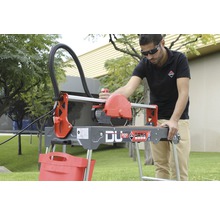 Mann bedient Fliesenschneider Rubí DU 200 EVO auf einem Rasen