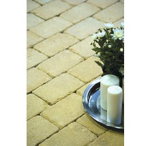 Pflastersteine im Fischgrätenmuster mit Kerzen und Blumenarrangement