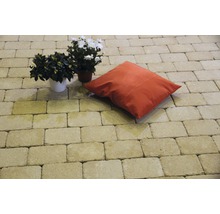 Terrasse gepflastert mit Betonpflastersteinen, Dekokissen und Topfpflanzen