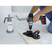 Bohren einer Fliese mit einer Bohrmaschine, einem Wasserbehälter und einer Saugvorrichtung