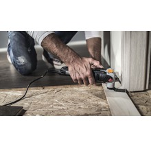 Mann verwendet Multifunktionswerkzeug zum Schneiden eines Holzstücks