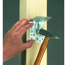 Eckverbinder wird mit einem Hammer an einem Holzbalken befestigt.