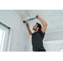 Ein Mann benutzt eine Wasserwaage für Renovierungsarbeiten im Innenbereich.