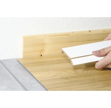 Sockelleiste wird an Holzwand angebracht