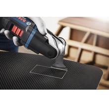 Eine Person verwendet ein Multifunktionswerkzeug von Bosch, um ein Rechteck in ein Material zu schneiden.