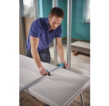 Ein Mann schneidet Gipskartonplatten mit einem Gipskartonschneider.