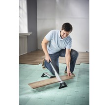 Mann schneidet Laminat mit einem Laminatschneider