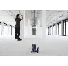 Ein Mann arbeitet mit einem Linienlaser in einem Rohbau zur Ausrichtung.