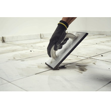 Fliesenleger mit Fugengummi beim Verfugen von Fliesen