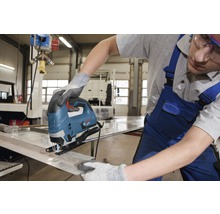 Eine Person benutzt eine Stichsäge, um ein Metallstück zu schneiden.