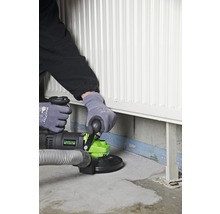 Eine Person verwendet eine Betonschleifmaschine in der Nähe eines Heizkörpers.