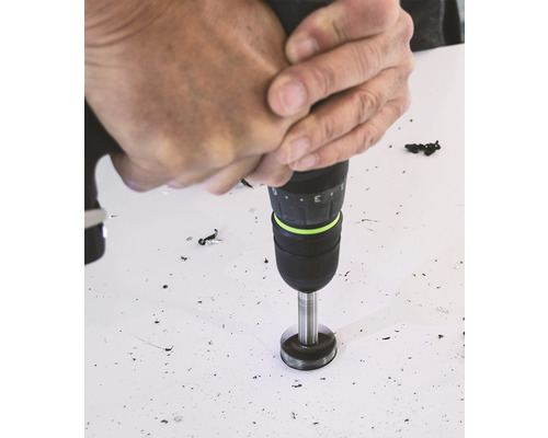 Eine Person bohrt mit einer Bohrmaschine ein Loch in eine Oberfläche.