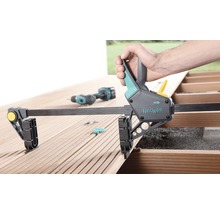 Wolfcraft Einhandzwinge auf einer Holzterrasse in der Anwendung mit einem Akkuschrauber