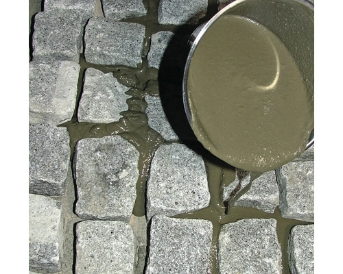 Pflastersteine werden mit Fugenmörtel gefüllt.