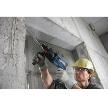Mann bohrt mit einem Bosch Bohrhammer in eine Betonwand