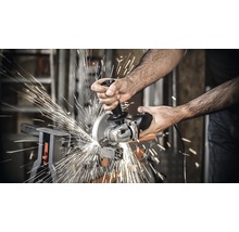 Eine Person schneidet Metall mit einem Winkelschleifer, wobei Funken entstehen.