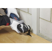 Eine Person benutzt ein Multifunktionswerkzeug von Bosch zum Schneiden von Holz.