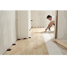 Verlegen von Laminat mit Werkzeugen und Abstandshaltern in einem Raum.