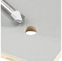 Fliesenbohrer neben einem Loch in einer Fliese