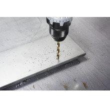 Ein Bohrer bohrt ein Loch in eine Metallplatte.