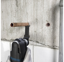 Multifunktionswerkzeug schneidet Kupferrohr an einer Wand