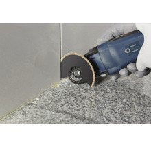 Multifunktionswerkzeug im Einsatz zum Entfernen von Fugen zwischen Fliesen.