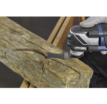 Multifunktionswerkzeug beim Bearbeiten eines Holzbalkens mit Nägeln.