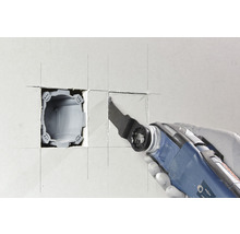 Oszillierendes Elektrowerkzeug schneidet eine Öffnung in eine Wand für eine Gerätedose