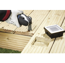 Oszillierendes Elektrowerkzeug beim Schneiden einer Holzterrasse für eine Bodeneinbauleuchte