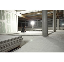 Mann arbeitet in einem Raum mit Gipskartonplatten und Metallprofilen