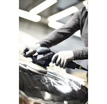 Eine Person poliert mit einer Poliermaschine eine Oberfläche.