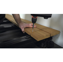 Terrassenbau: Schraube wird in Holzdiele geschraubt