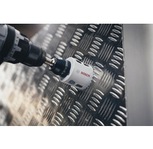 Bohrmaschine mit Bosch Logo beim Bohren eines Lochs in eine Metalloberfläche