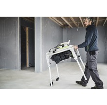 Mann transportiert Tischkreissäge auf Baustelle