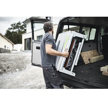 Mann lädt Tischkreissäge in Transporter