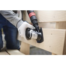 Person arbeitet mit einem oszillierenden Multitool an einem Holzstück.