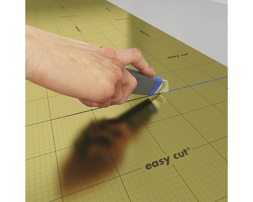 Hand schneidet Dämmunterlage mit einem Cuttermesser.