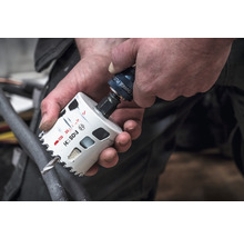 Eine Person befestigt eine Lochsäge am Bohrfutter.