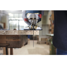 Eine Stichsäge schneidet ein Holzbrett.