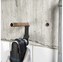 Multifunktionswerkzeug beim Kürzen eines Kupferrohrs an einer Wand