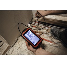 Eine Inspektionskamera mit Kabel wird verwendet, um Rohre in einem unaufgeräumten Bereich zu überprüfen.