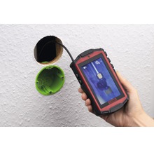 Eine Inspektionskamera wird verwendet, um in eine Wandöffnung zu schauen.