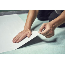 Verlegen einer Renovierungsplatte durch eine Person.