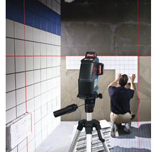 Fliesenleger verwendet einen Kreuzlinienlaser zur Ausrichtung von Fliesen an der Wand.