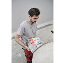 Ein Mann schüttet Betonmischung in einen Betonmischer.