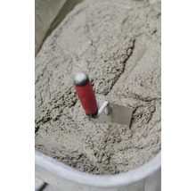 Eimer mit angerührtem Beton und einer Maurerkelle