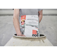 Person trägt einen Sack Garten- und Landschaftsbeton