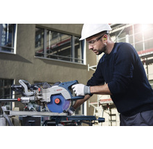 Ein Mann mit Schutzhelm und Schutzbrille bedient eine Bosch Kappsäge.