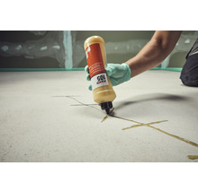 Handwerker trägt mit einer Kartusche Klebstoff auf einen Untergrund auf