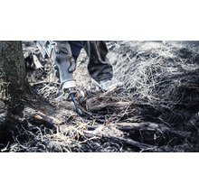 Eine Person benutzt eine Säbelsäge, um Wurzeln zu schneiden.